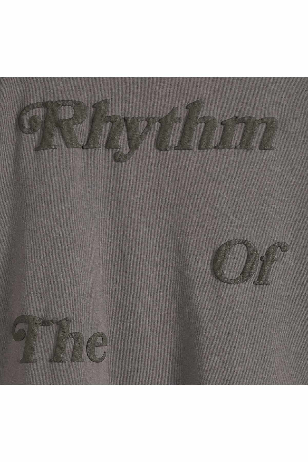 Dark gray graphic T-shirt fabric close-up with Rhythm and Or text