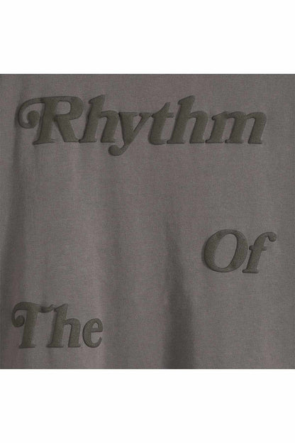 Dark gray graphic T-shirt fabric close-up with Rhythm and Or text
