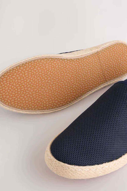 Navy slip-on espadrille shoes showing tan textured outsole