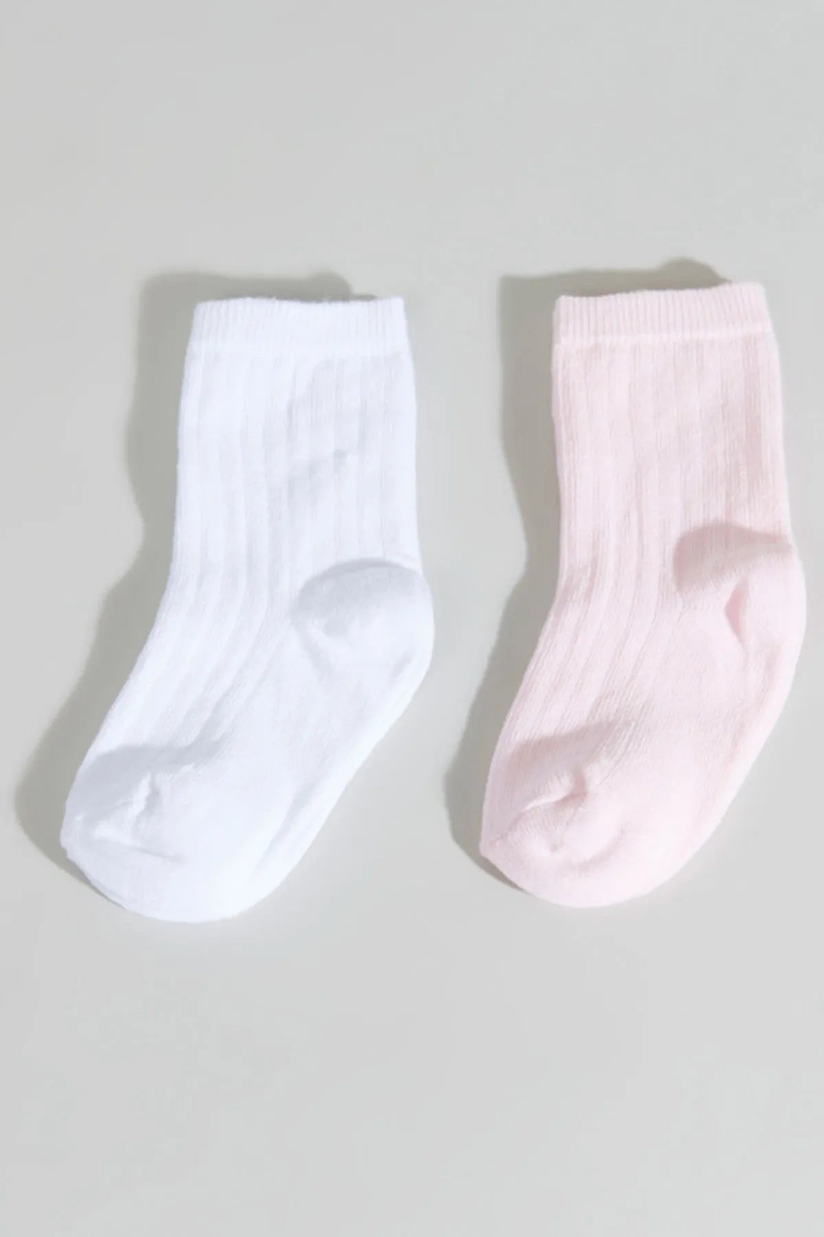 Baby ankle socks, one white and one light pink, ribbed knit