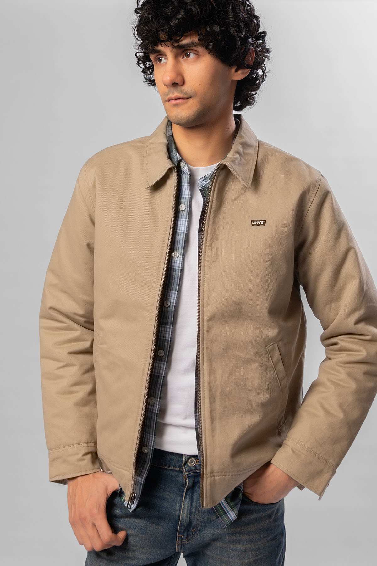 Men's Levi's beige jacket with logo patch and plaid shirt peeking at neckline