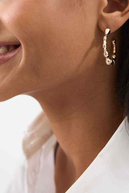Gold bamboo-style hoop earrings with textured link detail