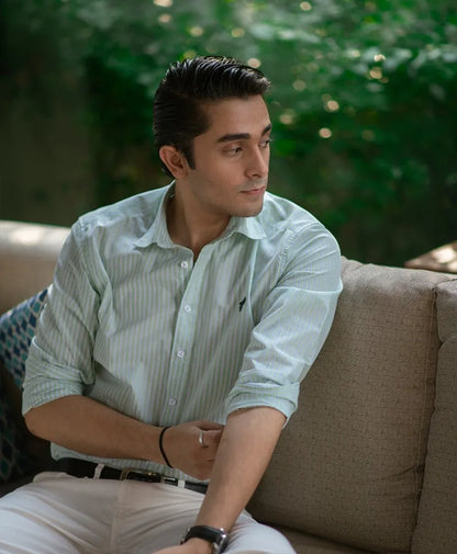 Light blue striped button-up shirt with button placket and collar, seated