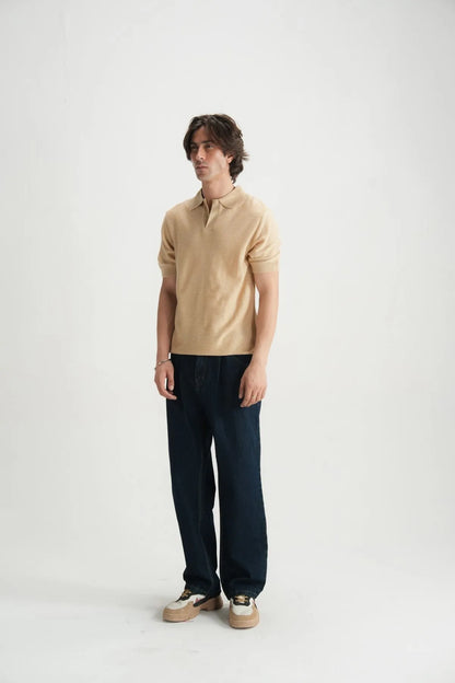 Beige polo shirt with open collar and short sleeves, relaxed fit.