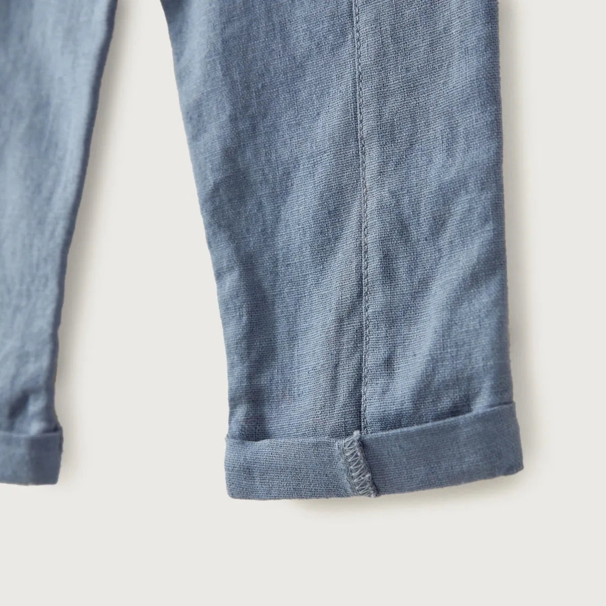 Blue baby trousers cuffed hem with stitched leg seam and textured fabric finish