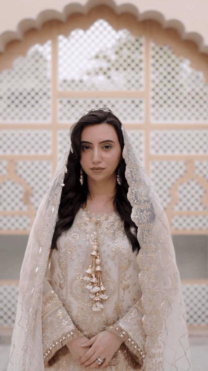 Cream embroidered long dress with sheer veil-style dupatta and ornate neckline tassels