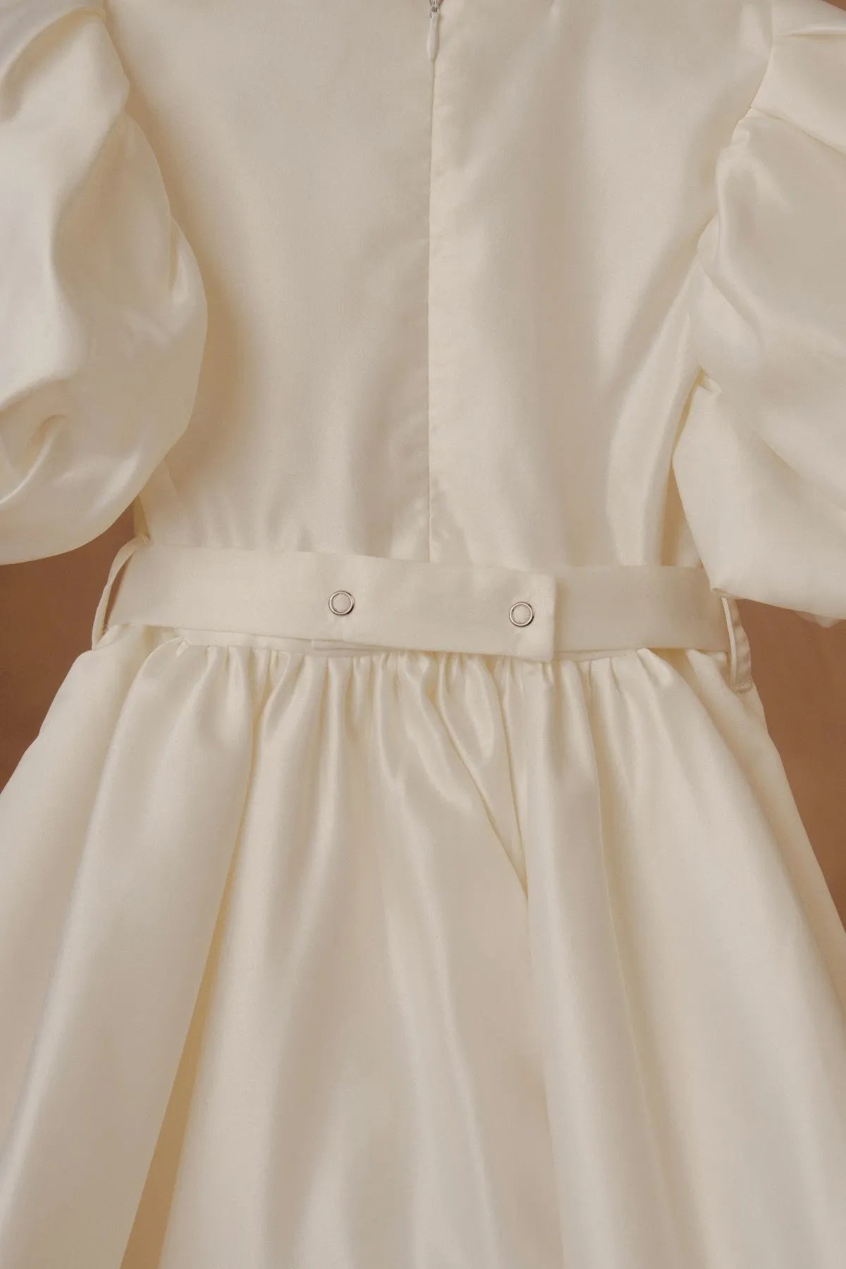 White dress close-up: fitted top with snap buttons at waistband