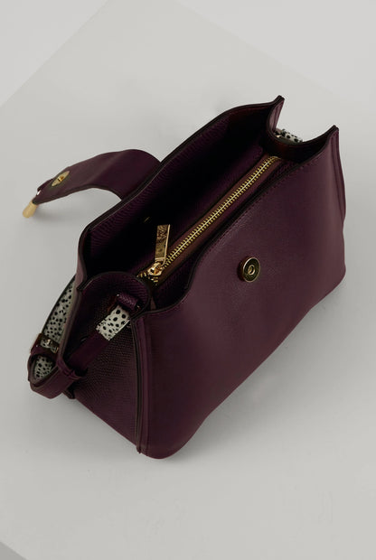 Purple mini bag with front zipper, gold hardware, and interior fabric view