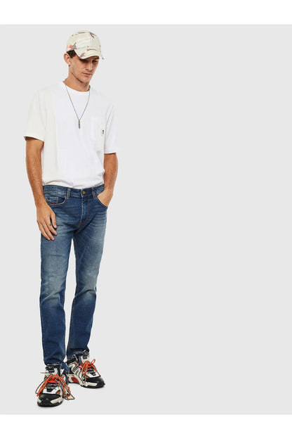 Diesel blue denim jeans worn with sneakers and a white short-sleeve shirt