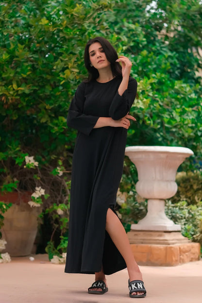 Black long-sleeve maxi dress with round neck, side slit and full-length hem