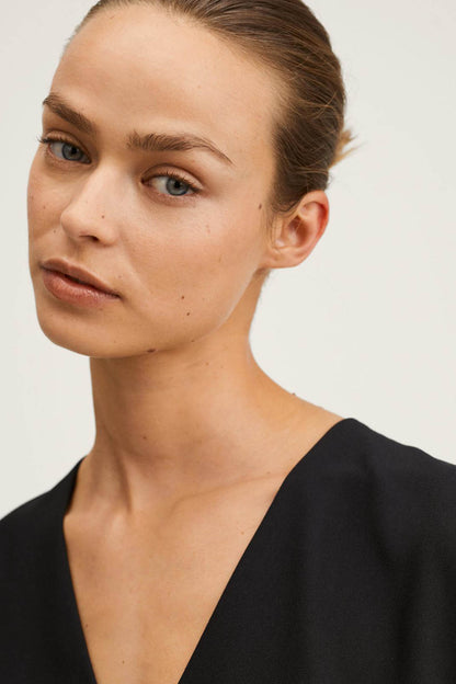 Black sleeveless V-neck jumpsuit neckline detail