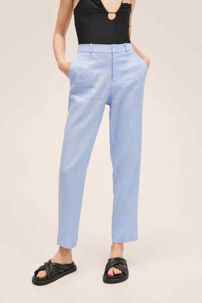 Sky-blue cropped trousers with cuffed hem and black slide sandals