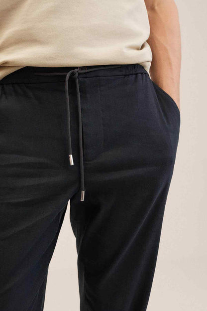 Dark navy drawstring jogger-style trousers with white drawcord