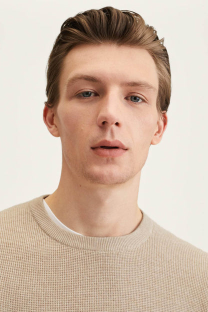 Beige crewneck knit sweater close-up with fine textured fabric