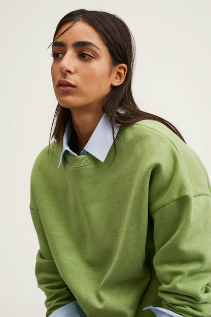 Green crewneck sweatshirt close-up with crew neckline and textured knit