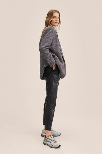 Black tapered trousers with side pockets and elastic waist, ankle-length hem
