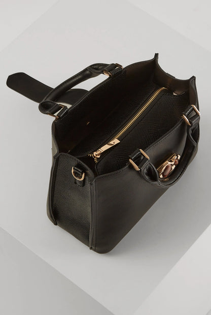 Black handbag with top handle, buckled side straps, and gold-tone zip compartment