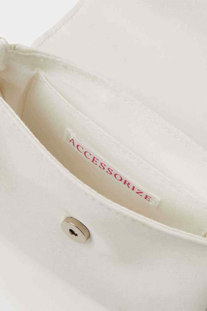 Ivory handbag interior lining with ACCESSORIZE logo near side seam