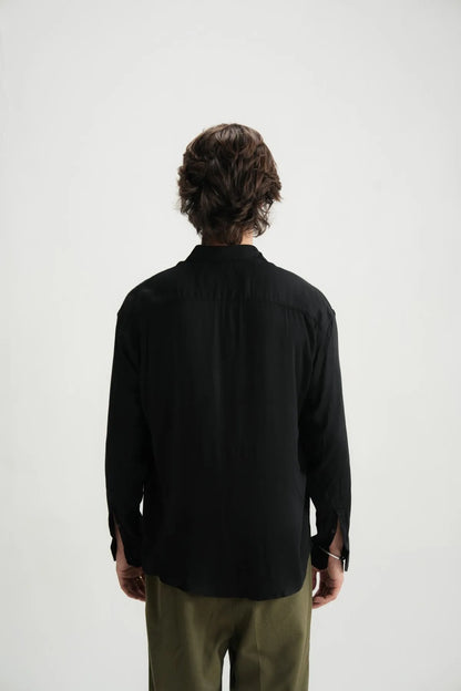 Black button-up shirt back view from behind, relaxed shoulders and long sleeves.
