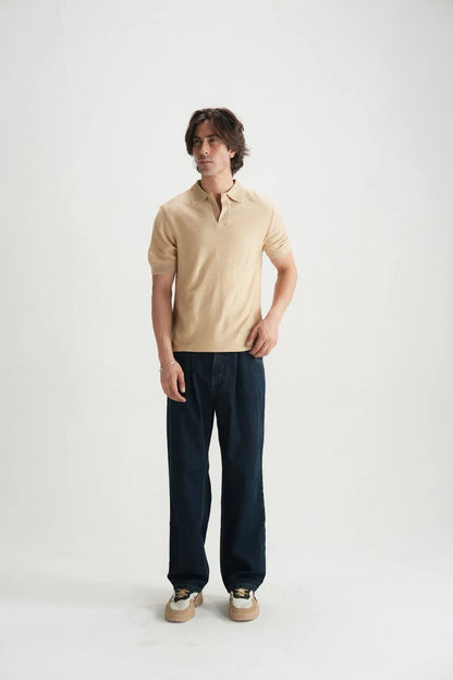 Beige polo shirt on model, short sleeves and open collar.