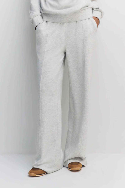 Grey wide-leg jogger trousers with drawstring waist and relaxed full-length legs
