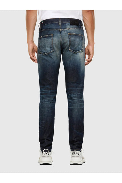 Men's blue distressed jeans on model, back view, five-pocket styling
