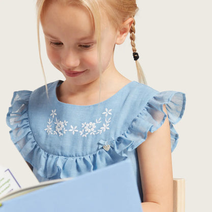 Blue baby dress close-up with ruffled shoulder sleeves and white floral embroidery