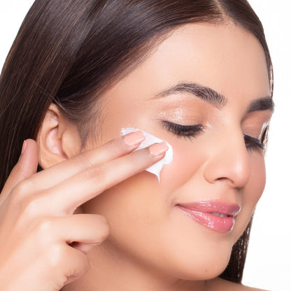 Face cream applied near the eye with a small scoop on fingertip