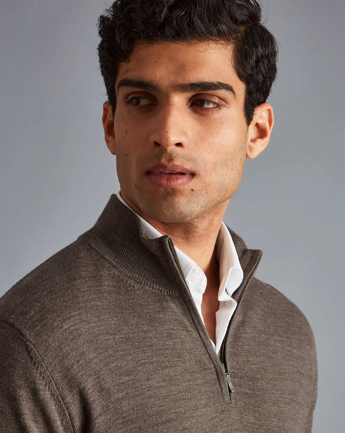 Men's brown quarter-zip sweater close-up, zip pull and ribbed collar