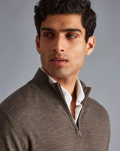 Men's brown quarter-zip sweater close-up, zip pull and ribbed collar
