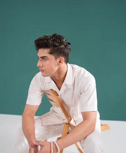 Off-white fitted V-neck short-sleeve button-up shirt and matching pants, close-up