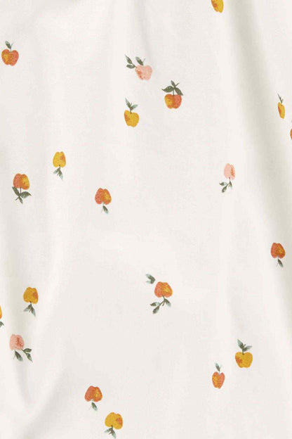 White fabric with scattered small fruit prints, close-up