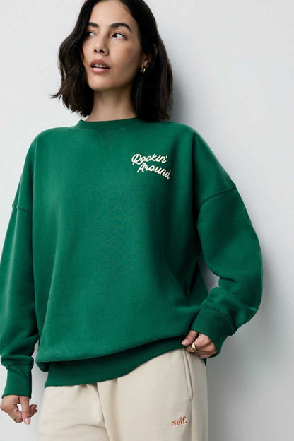 Forest green crewneck sweatshirt with 'Rockin' Around' text on chest