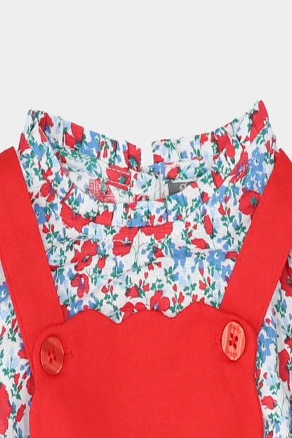 Floral ruffle top with red pinafore straps and round buttons