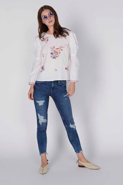 White embroidered long-sleeve blouse with floral patchwork and gathered cuffs