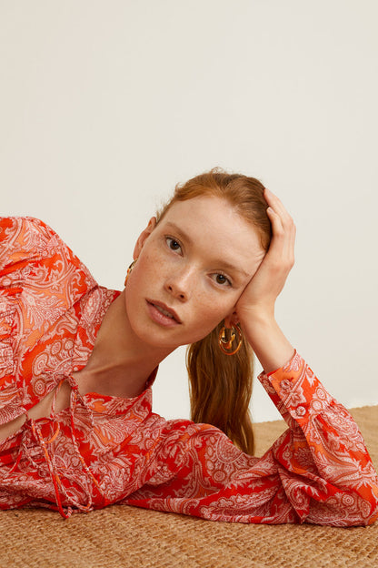 Orange printed blouse with tie-neck and long sleeves, close-up