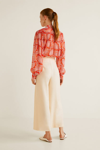 Orange printed blouse with tie-neck and long puff sleeves, back view