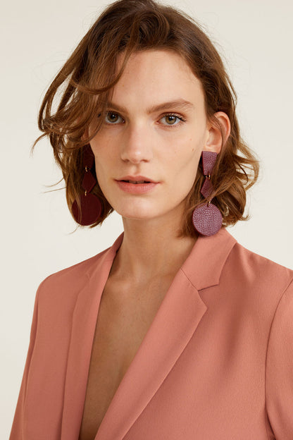 Dusty pink blazer lapels and neckline with large dangling earrings
