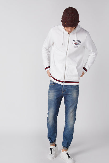 White zip-up hoodie with chest logo patch and red/blue striped cuffs and hem