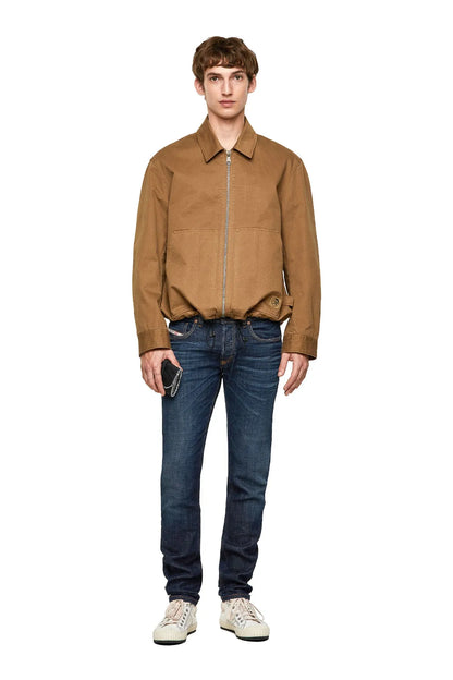 Light brown Diesel zip-up jacket worn with dark jeans and sneakers