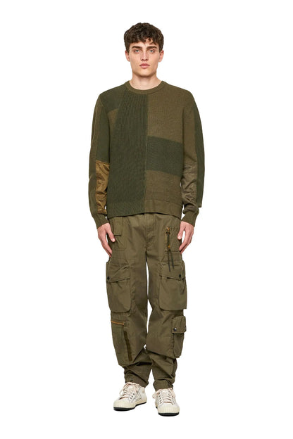 Diesel green patchwork crewneck sweater with long sleeves worn with cargo pants