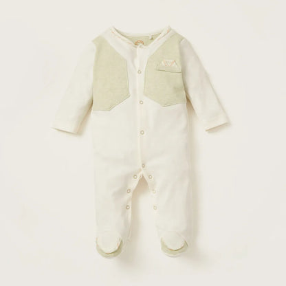 Baby footed onesie romper in off-white with light green chest panel and snap buttons
