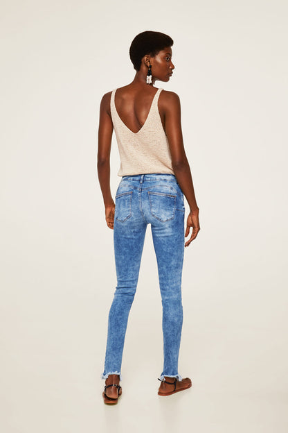 Indigo blue denim jeans, skinny fit, rear view with cuffed hem