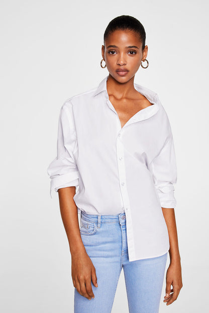Light blue denim jeans with frayed hem, model wearing with white shirt