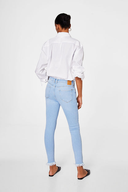 Light blue denim jeans, back view, frayed hem and slim fit
