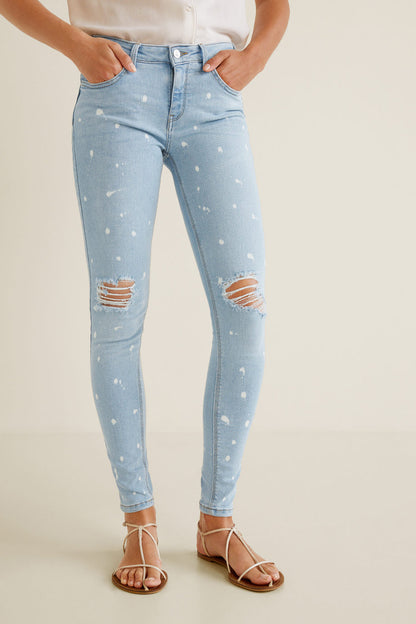 Light blue skinny jeans with white speckle and ripped knee patches, front view