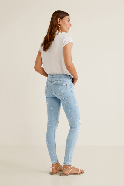 Light blue slim jeans with white speckle, rear view, distressed rips