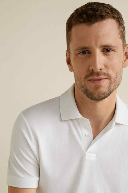 White polo shirt close-up with fold-over collar and single-button placket