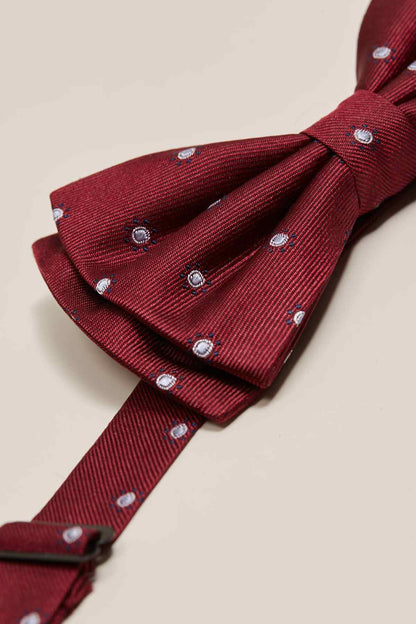 Red bow tie knot with small dot studs on textured fabric