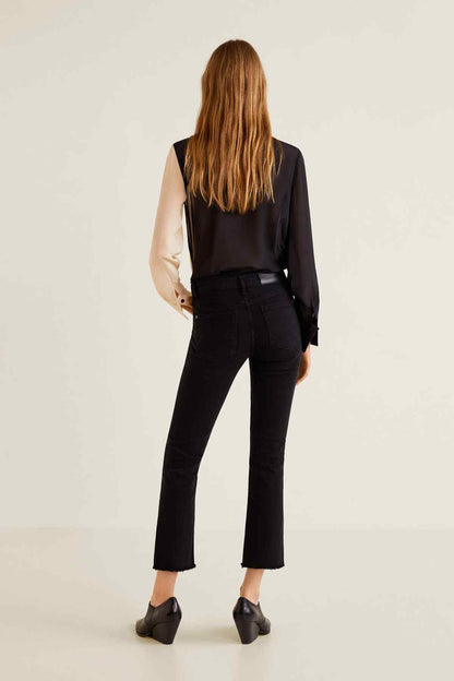 Back view of black denim jeans with fitted straight leg and cuffed ankle hem